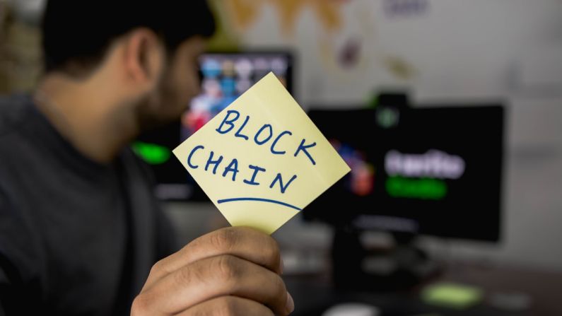 Blockchain - person holding sticky note